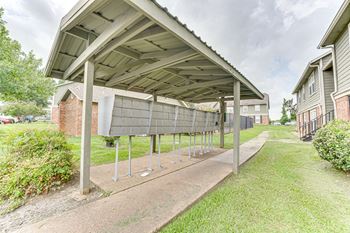 Covered carport structure with metal posts and drive path